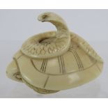 A Japanese carved ivory Netsuke of a turtle and Cobra, early 20th century. Height:2.8cm. Signed to
