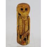 A naively carved bone figure of a skeleton holding one hand to it's head. Age and origin unknown.