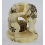 A finely carved Japanese ivory Netsuke, early 20th century, of a man grooming a horse, decorated