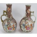 A pair of antique Chinese porcelain ewers with ornate decoration and applied dragon handles.