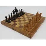 A hand carved olive wood and ebony chess set in folding chess board box. Tallest piece 9cm.