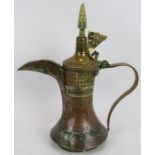 A large antique middle Eastern Dallah coffee pot of copper and brass construction. Height 44cm.