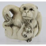 A Japanese carved ivory Netsuke early 20th century, of a monkey and dog. Height: 3.2cm. Signed to