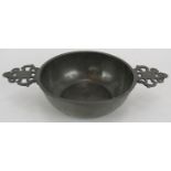 A large 18th century pewter porringer with pierced handles bearing touch marks. Diameter: 17cm.