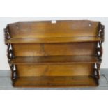 An Arts & Crafts medium oak wall hanging bookshelf with carved and pierced sides depicting