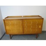 A mid-century 1950s walnut & elm sideboard for Heals, the sliding doors opening onto a fitted