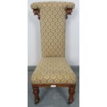 A Victorian walnut prie dieu upholstered in a patterned brocade material, on tapering octagonal
