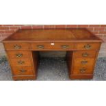 An Edwardian medium oak pedestal desk with inset gilt tooled leather writing surface, housing a