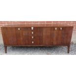 A mid-century Danish tropical hardwood sideboard with sycamore lined interior, housing four short,