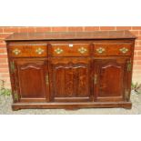 An 18th century oak sideboard/dresser base, having 3 short frieze drawers above two shaped fielded