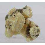 A finely carved Japanese ivory Netsuke, Meiji period, featuring a man and child. Height: 3.2cm.