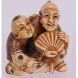 A very finely carved Japanese ivory Netsuke, Meiji period of a man with child holding a fan