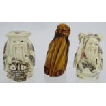 Two Japanese carved bone Okimono of travellers with red and black decoration both signed and a