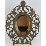 An ornate 19th century gilt brass Florentine style vanity mirror with bevelled glass and folding