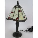 A contemporary Tiffany style lamp with white and red berry pattern glass shade and bronzed fittings.