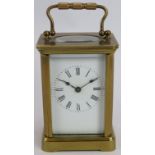 A small brass 8 day carriage clock in glazed case with enamel dial. Height 14cm. No key. Condition