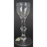 An 18th century drinking glass with engraved bowl facet cut single knop stem and conical foot.