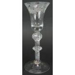 An 18th century air twist drinking glass with engraved bowl, double knop stem and conical foot.