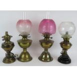 Two brass oil lamps, both etched Cranberry shades and two similar lamps converted to electricity,