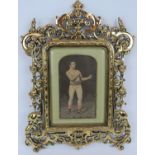 An antique heavy brass Art Nouveau picture frame with a silk work picture of a Pugilist with