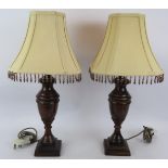 A pair of contemporary baluster urn lamps with burnished bronze finish and square beaded shades.