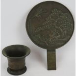 A Japanese Meiji period bronze mirror diameter 24cm and a small antique bronze mortar. (2).