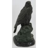 A well cast bronze figure of a bird of prey perched on a rock on black marble plinth. Signed Barrie.