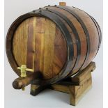 A large coopered oak cider or beer barrel with oak cradle. Length 63cm. Diameter 42cm. Condition