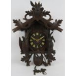 A large Black Forest style cuckoo clock with carved hunting themed animals. Height 60cm. Condition