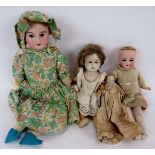 Four small antique dolls, two marked made in Germany, the smallest has porcelain arms and a silk