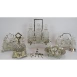 A three decanter silver plated tantalus, three plated cruet sets including an Art Deco example, a