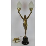 An Art Deco Lorenzl style bronzed figural lamp of a semi nude holding two flames. Black marble
