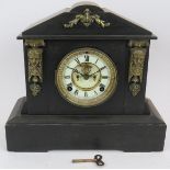 A late Victorian slate striking mantel clock with enamel dial and Ansonia Clock Co movement. Key and