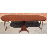 An antique mahogany extending circular dining table, the radial veneered top inlaid with ebony, over