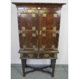 An 18th century and later hardwood Zanzibar cabinet on stand, with ornate brass mounts and studwork,