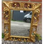 A Florentine style rectangular giltwood wall mirror, with carved and pierced surround. Condition