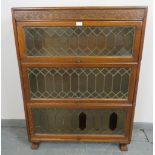 An early 20th century oak three section Globe-Wernicke type bookcase with carved frieze and glazed