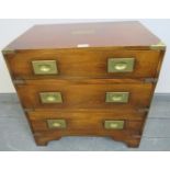 A small mahogany campaign style chest of three long drawers with brass mounts and campaign drop