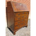 A Georgian Revival walnut bureau, featuring crossbanded inlay, the fall front opening onto a