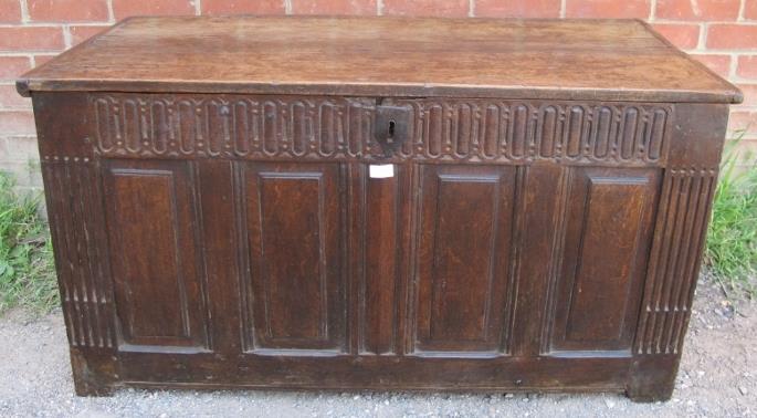 A 17th century oak coffer, with chisel carved frieze and internal candlebox, the fielded front