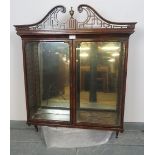 A Regency mahogany wall hanging glazed display cabinet, the scrolled and pierced cornice with