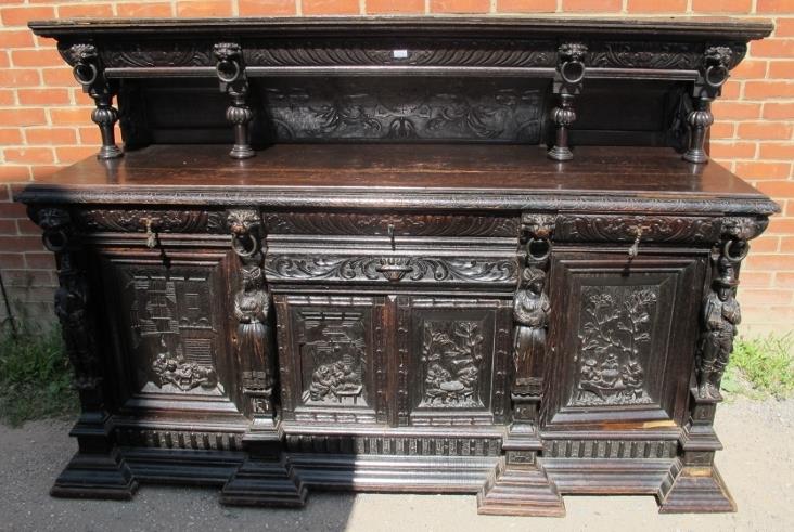 A large oak 19th century sideboard, ornately carved in a 16th century taste with lion masks and