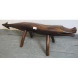 A hand carved fruitwood footstool in the form of a mythical crocodile/dragon creature. Condition