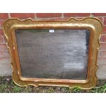 A 19th century cabaret wall mirror in a shaped gilt gesso frame, with engraved decoration, retaining