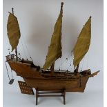 A wooden scale model of a Chinese junk complete with brass cannons. Brought back by the vendor's