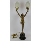 An Art Deco Lorenzl style bronzed figural lamp of a semi nude holding two flames. Black marble