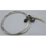 Two silver bangles joined together with a small group of charms to include an amethyst bead, a