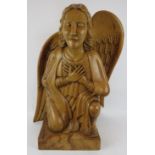 A large carved wood crouching angel, carved from hardwood and wax polished. One wing detached.