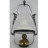 A ceiling mounted hanging oil lamp in black iron cradle. Height 66cm. Condition report: Chimney
