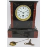 A Victorian black slate and red marble cased mantel clock with enamelled dial. Key and pendulum